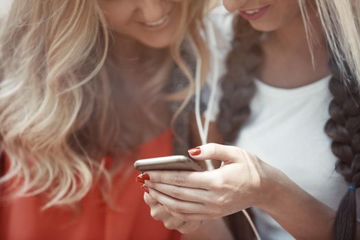 Girlfriends using smartphones outdoors
