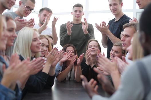 group of young diverse people applauding sitting at the same tab