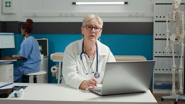 Portrait of general practitioner using laptop at health care checkup