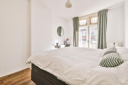 Bed near window in modern apartment