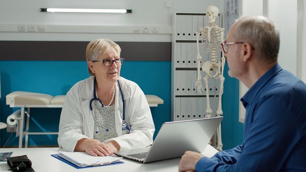 General practitioner having conversation with retired patient