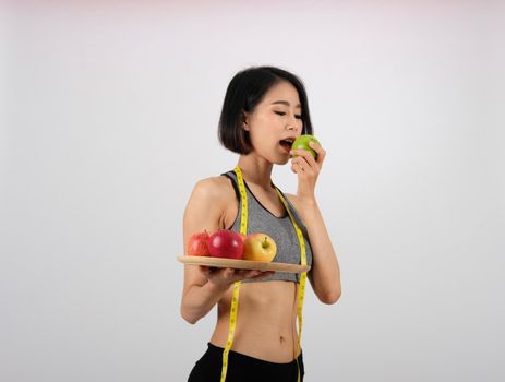 sporty fitness woman in sportswear with apple on white background. healthy sport lifestyle