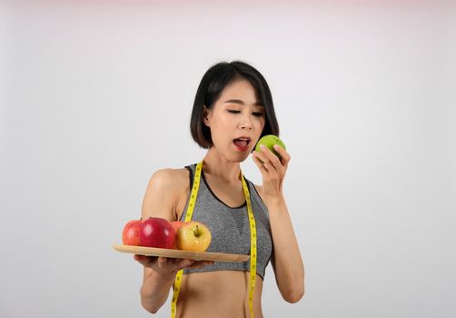 sporty fitness woman in sportswear with apple on white background. healthy sport lifestyle