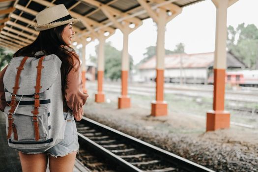 woman  backpacker traveler with backpack at train station. journey trip travel concept