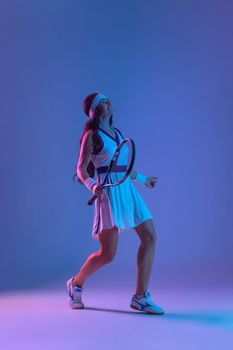 Tennis player with racket in sportswear. Woman athlete playing dark background.
