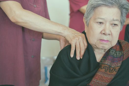 physiotherapist massage old woman shoulder