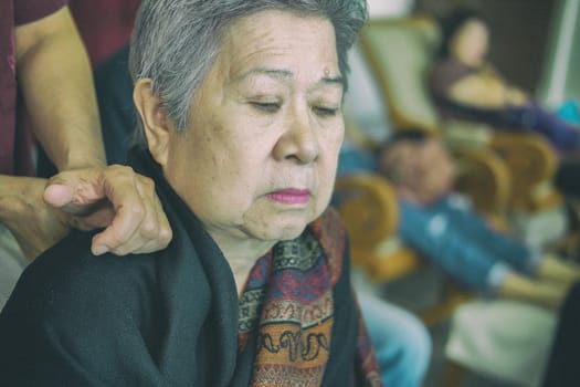 physiotherapist massage old woman shoulder