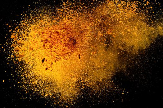 Explosion, Splashes of turmeric on a black background. India Seasoning. The orange powder of the turmeric root.
