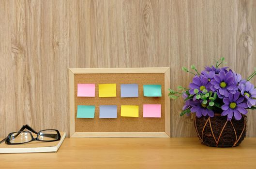 sticky notes reminder on cork board & notebook. education workspace concept