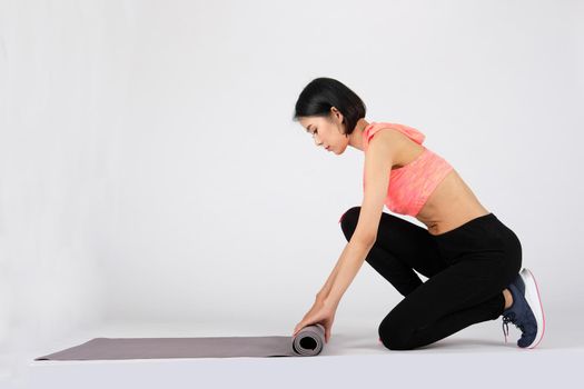 sporty fitness woman in sportswear with yoga mat on white background. healthy sport lifestyle