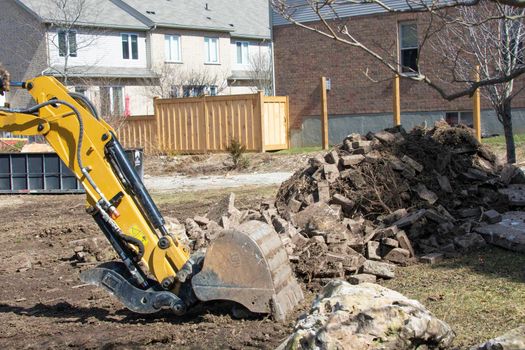 Excavator clearing a site for the construction of a cottage
