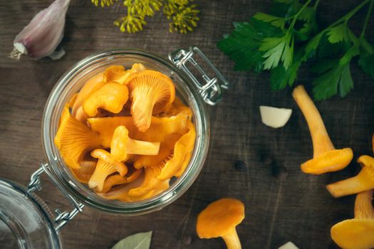 Preserving chanterelle mushrooms in a jar with spices and herbs. Pickling wild edible mushrooms. Flatlay, topview.