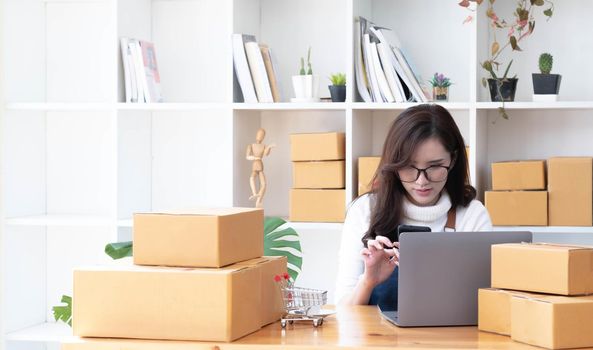 Startup small business entrepreneur SME, asian woman receive order on phone. Portrait young Asian small business owner home office, online sell marketing delivery, SME e-commerce telemarketing concept