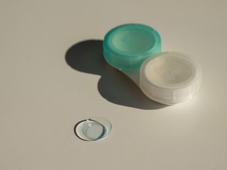 Contact lenses and a storage container on a white table.
