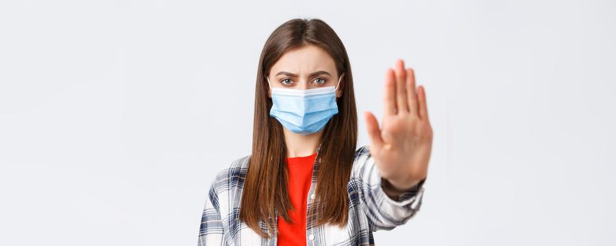 Coronavirus outbreak, leisure on quarantine, social distancing and emotions concept. Close-up of serious determined young woman want prevent or stop smth, stretch hand in restriction or warning