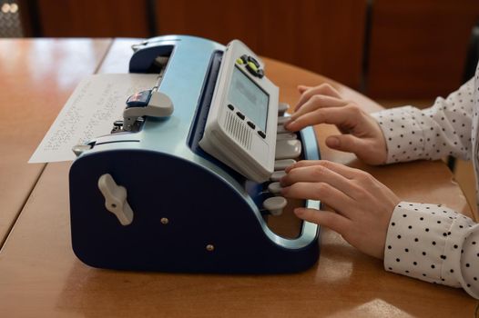 Blind woman using braille typewriter.