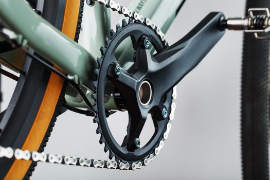 The leading star of a bicycle with a connecting rod and a chain close-up