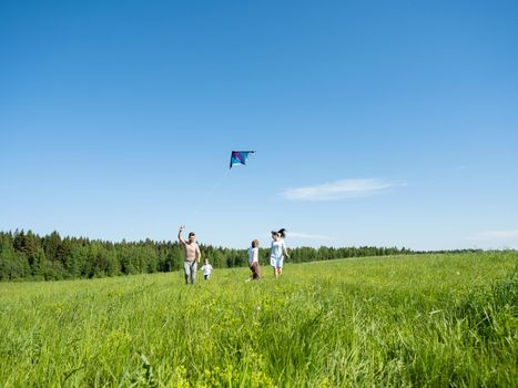Family running through field with fly