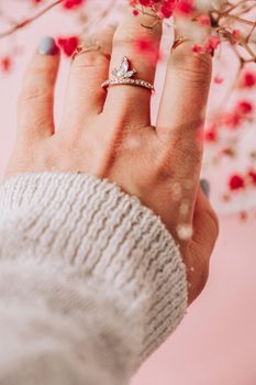 Baby's breath. Suggestion. Woman's hand with jewelry rings. Jewelry and luxury concept. Beautiful woman with stylish accessories. Plant Aesthetics
