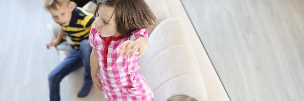 Toddlers dancing on sofa indoors