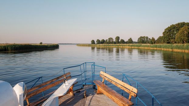 Landscape with boat front and river delta on a warm summer evening.