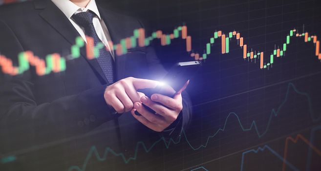 Man using smartphone with graphs analysis candle line and foreign currency rate on bokeh colors light. Manager analyzing investment statistics and indicators on dashboard for trading products.