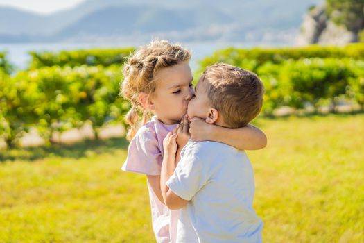 Portrait of two cute adorable baby children toddlers hugging and kissing each other, love friendship in childhood concept, best friends forever.