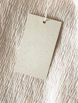 Blank fashion brand label tag, sale price card on luxury fabric background, shopping and retail