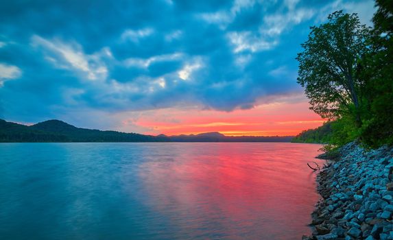 Dramatic colorful sunset along the shoreline of Cave Run Lake, KY.