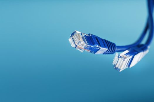 Two Ethernet Cable Connectors Patch cord cord close-up isolated on a blue background with free space