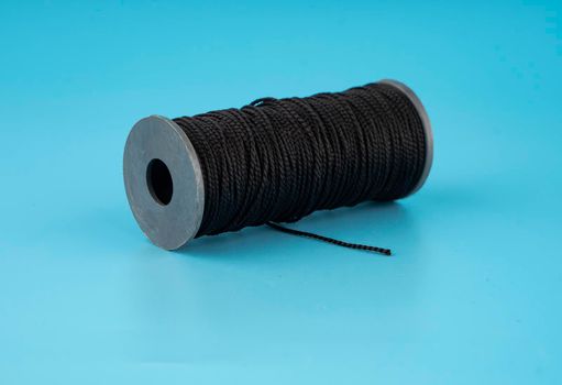 skein of black dense threads, on a blue background