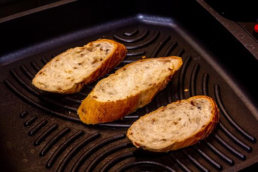 White bread toasted on an outdoor Grill on wooden table