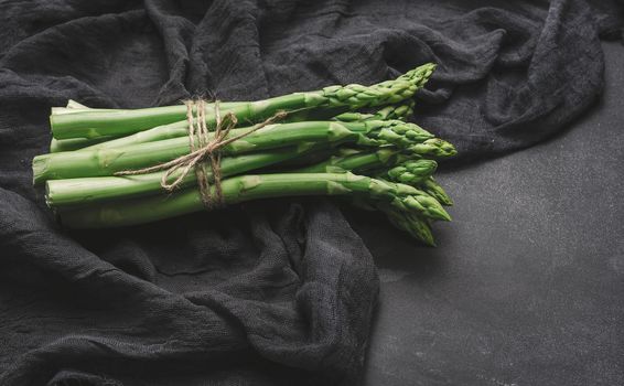 Fresh green asparagus sprouts on a black background