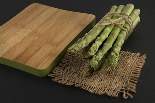 Asparagus tied with jute cord near cutting board