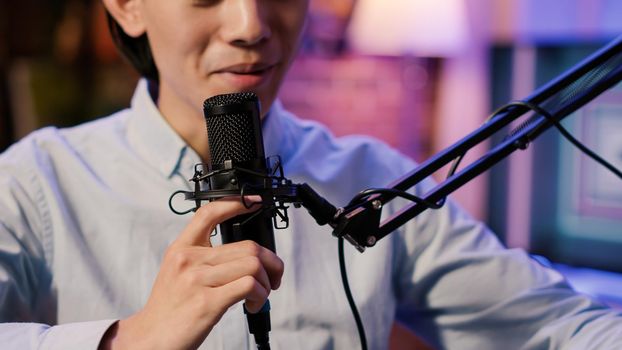 Internet vlogger recording podcast episode with microphone