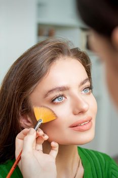 Professional make up artist applying powder