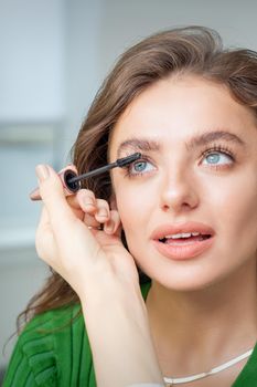 Makeup artist applies mascara on eyelash