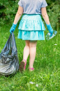 Little girl cleans plastic trash