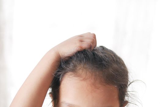 child Scratching Head Against white background .