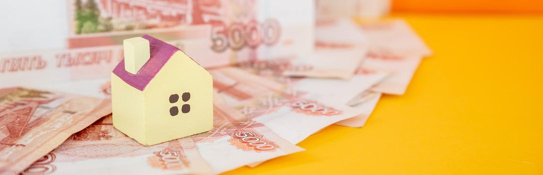 toy house on banknotes, buying your own home, mortgage, symbol of material well being.Buying a house or mortgage concept. Real estate price. Toy house on russian banknote background