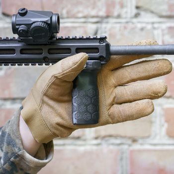 man hand in tactical glove hold front grip for a shot gun. Handgun im man hand ready to use. Shooter man ready to hit the target holding a hand grip