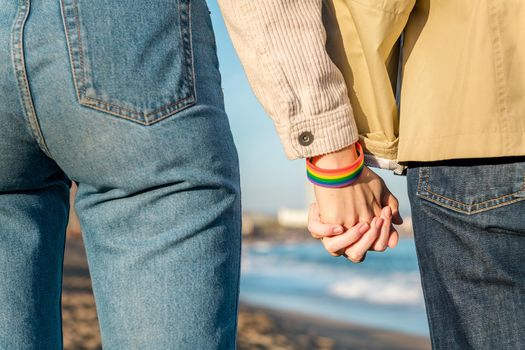 linked hands with rainbow flag bracelet