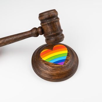 The judge hits a heart with a rainbow flag with a gavel.