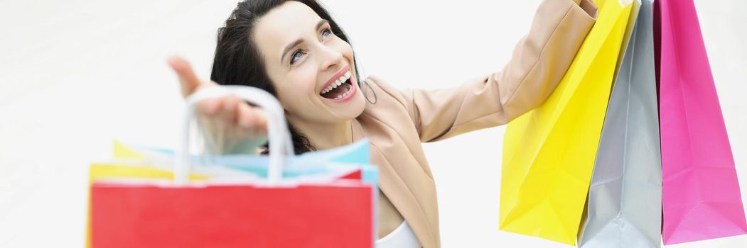 Young woman shopaholic laughing and being happy about bought things