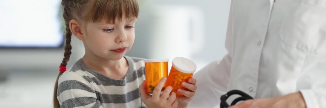 Child playing with bottles full of medication while on doctors appointment