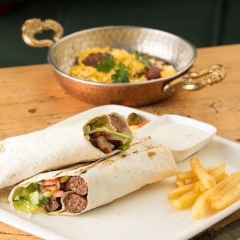 Closeup shot of kebabs with vegetables wrapped in a tortilla