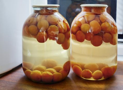 Home canning: apricot compote in glass jars.