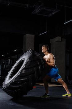 training - man flipping tire in gym
