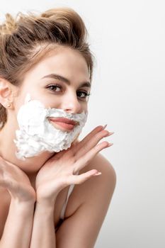 Woman with shaving foam on her face
