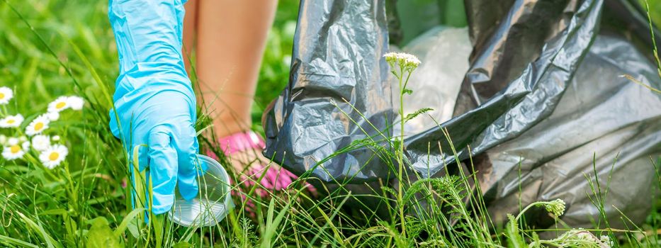 Child picks plastic trash from grass